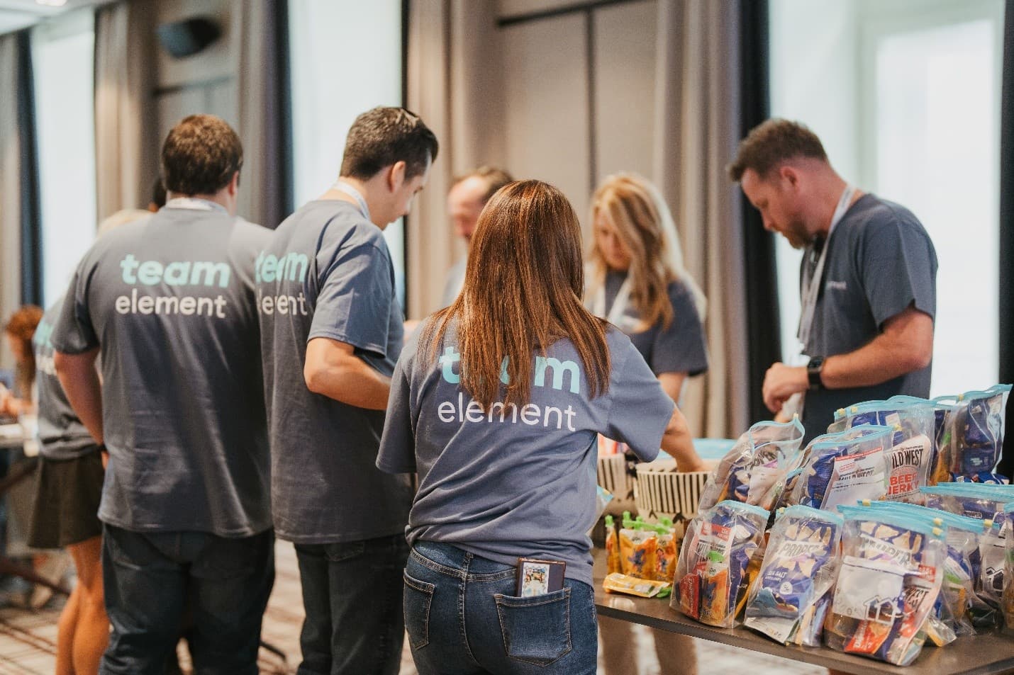 Employees assembling care packages during a volunteer event. Employees assembling care packages during a volunteer event.