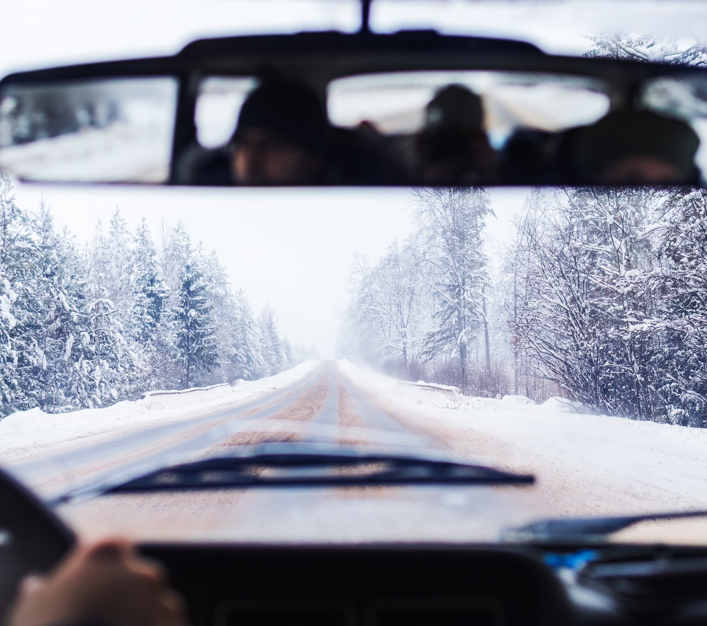 Fleet fuel management perspective from inside a vehicle driving on a snowy winter road, illustrating how cold weather conditions like snow-covered pavement and low temperatures reduce fuel economy. Fleet fuel management perspective from inside a vehicle driving on a snowy winter road, illustrating how cold weather conditions like snow-covered pavement and low temperatures reduce fuel economy.