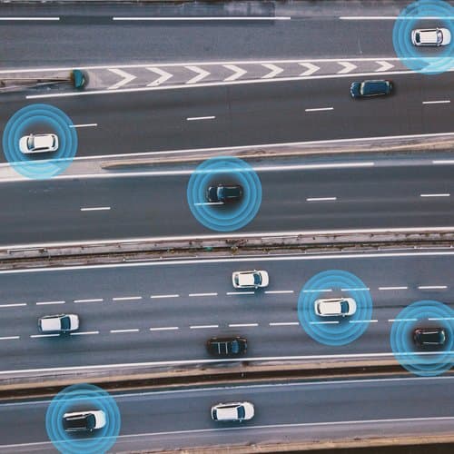 Aerial view of vehicles on a highway illustrating fleet technology with connected vehicle communication and real-time data monitoring. Aerial view of vehicles on a highway illustrating fleet technology with connected vehicle communication and real-time data monitoring.