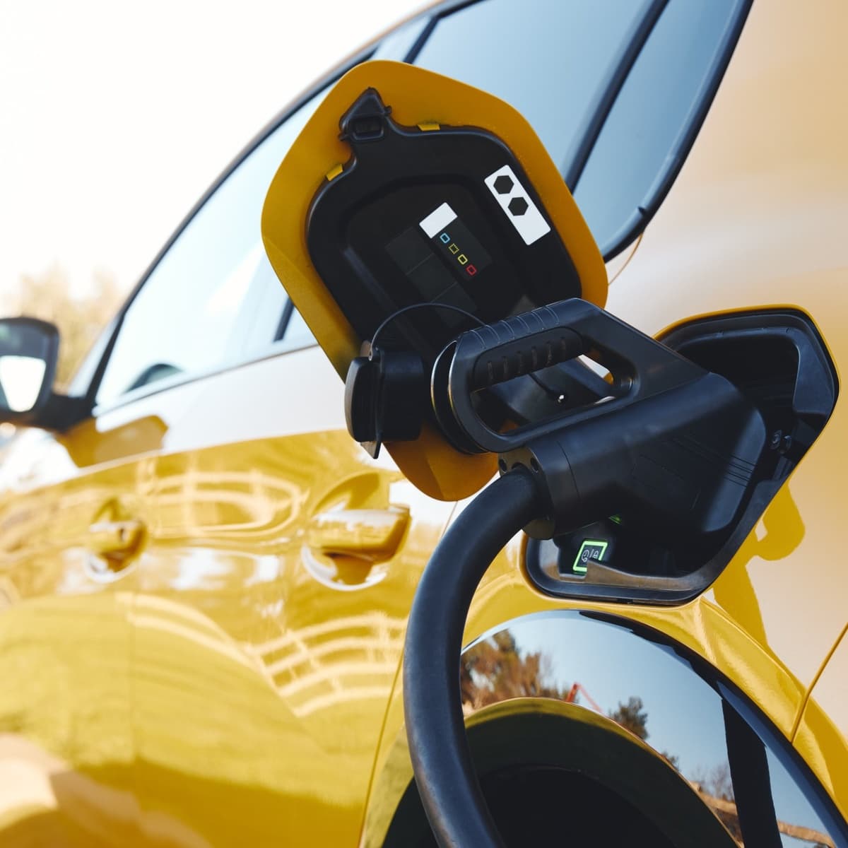 Close-up of a yellow electric fleet vehicle at a charging station, powering up for the route ahead. Close-up of a yellow electric fleet vehicle at a charging station, powering up for the route ahead.
