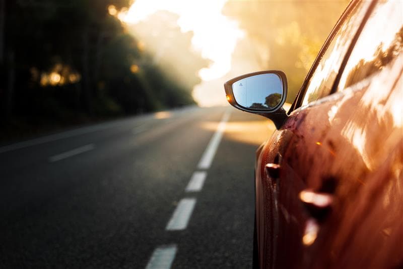A car driving on an open road during daylight A car driving on an open road during daylight