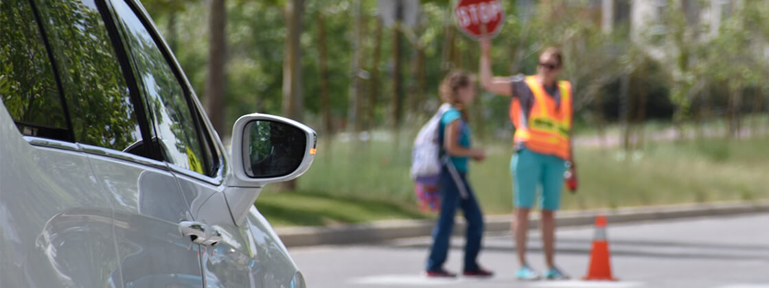 Car stopped at school crossing with kids