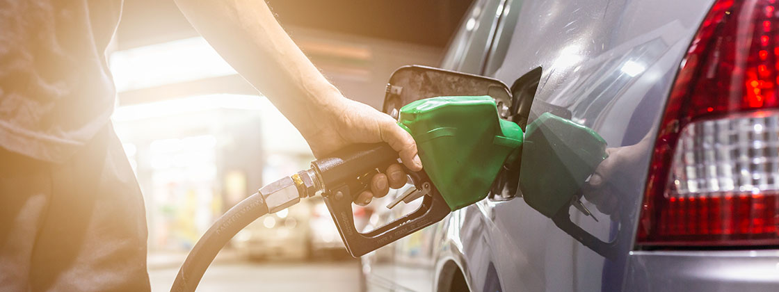 person holding gas pump filling car