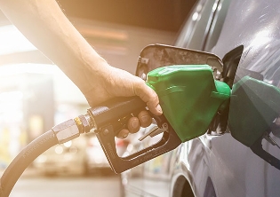 person holding gas pump filling car