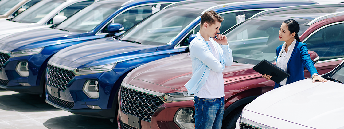 Fleet managers evaluating used cars on a dealership lot, amid remarketing and tariff changes