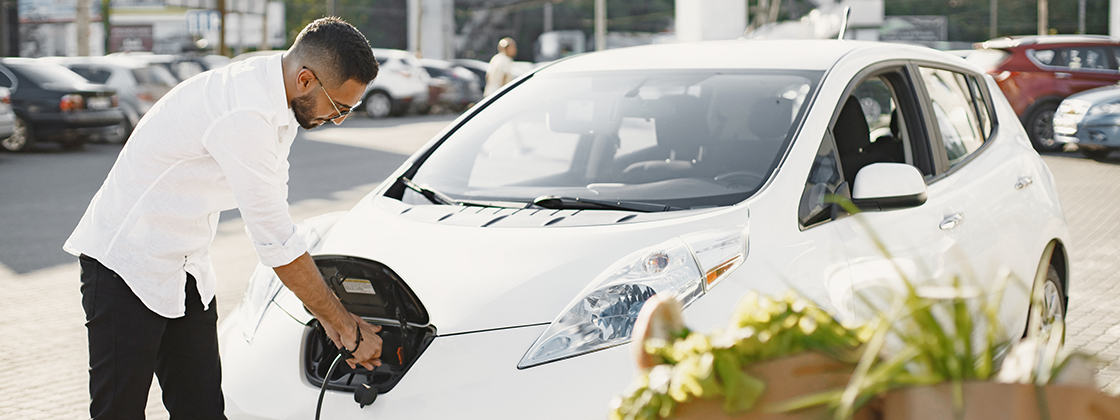 Fleet manager charging an electric vehicle as part of a sustainable fleet management strategy