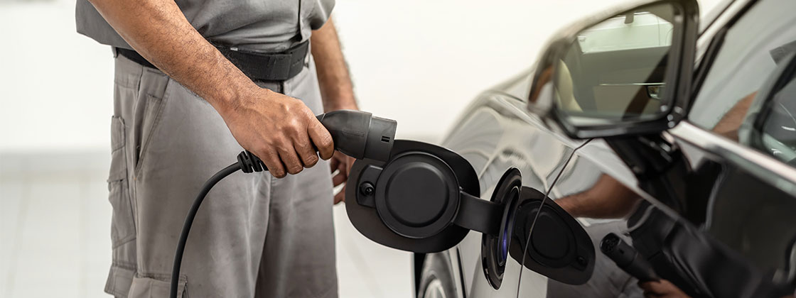 man plugging in electric vehicle