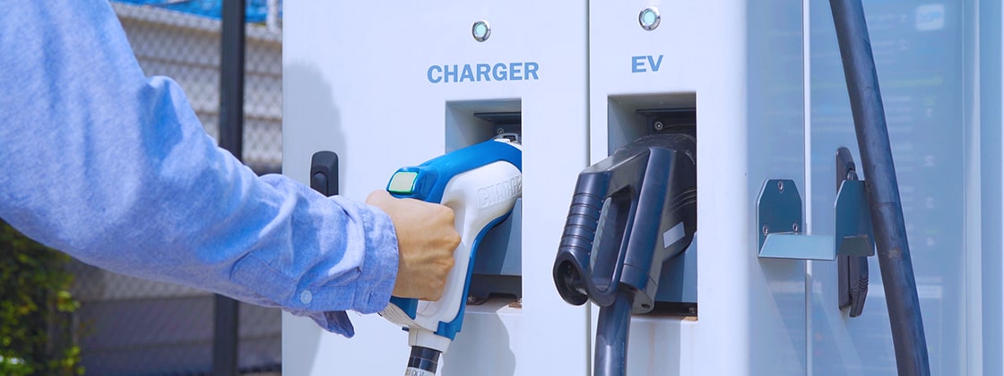 Man at electric charging station