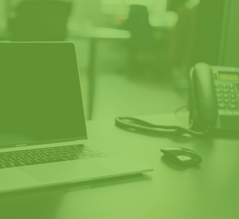 Image (teintée vert) d’un portable et d’un téléphone sur un bureau