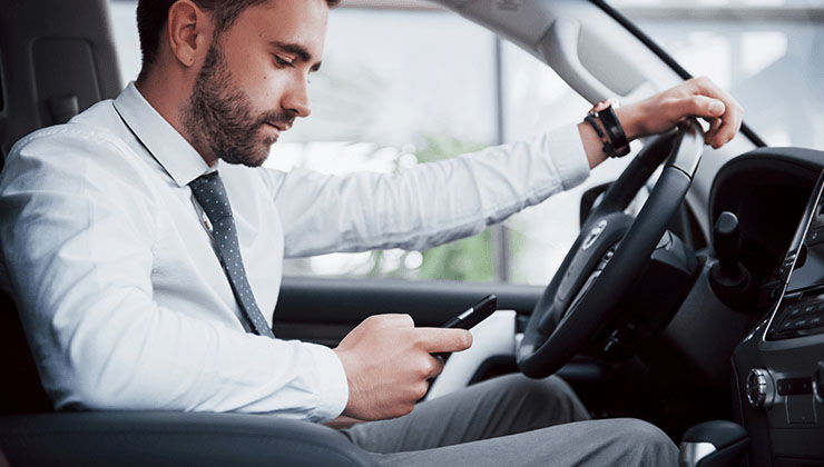 man driving and texting