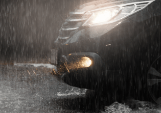 Black car driving in heavy rain