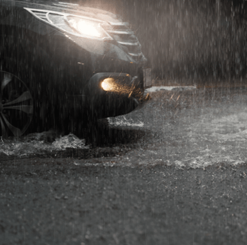 black car driving in rain storm