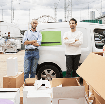 Two men in front of work van outside distribution facility