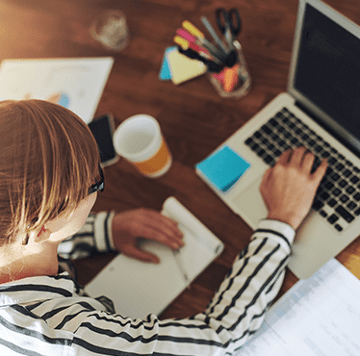 Woman at computer and note taking