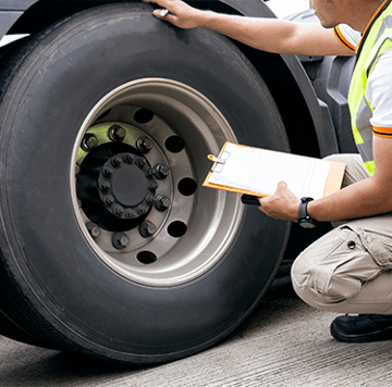 Technicien d’entretien inspectant un pneu