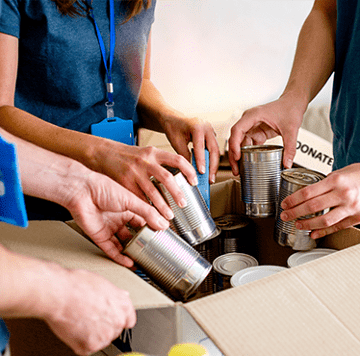 hands loading a box full of cans