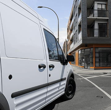 White service van turning a street corner