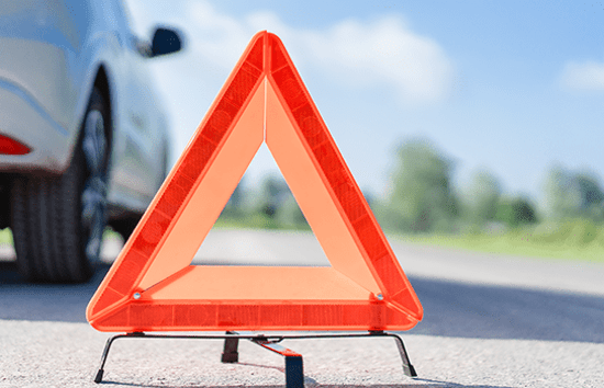 hazard sign on road next to car