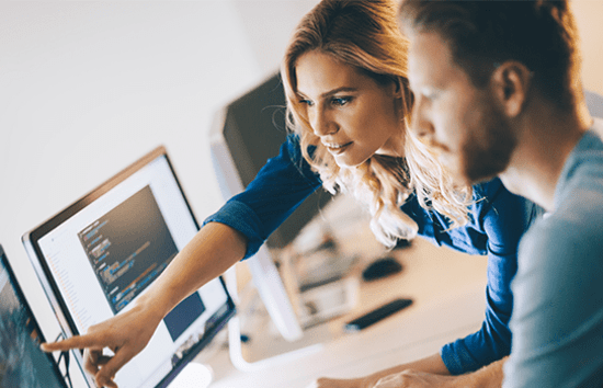 Business man and woman looking at computer monitor
